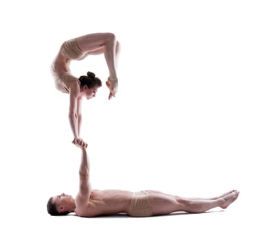 Young athletic gymnasts show acrobatic exercise in studio