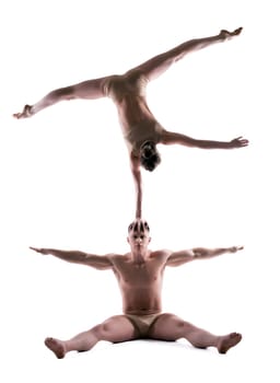 Athletic people showing acrobatic trick in studio, isolated on white