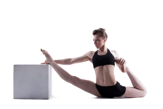 Sporty brunette doing stretching in studio, isolated on white