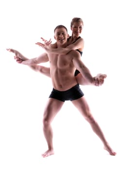 Two young smiling acrobats posing in studio, isolated on white
