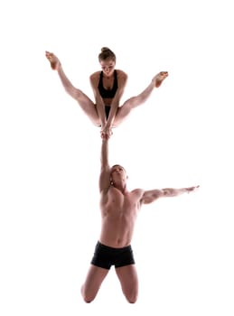 Attractive young people showing acrobatic trick in studio