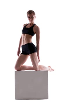 Sporty woman posing with cube looking at camera, isolated on white