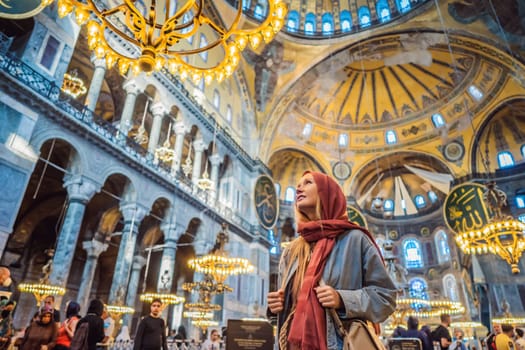 Woman tourist enjoying Hagia Sofia, Ayasofya interior in Istanbul, Turkey, Byzantine architecture, city landmark and architectural world wonder. Turkiye.