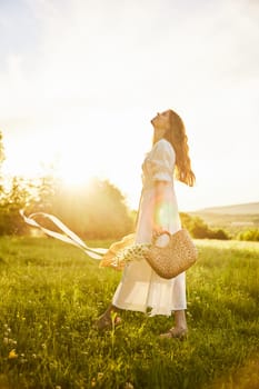 a beautiful woman in a hat and a light dress walks through a chamomile field with a basket full of daisies in the rays of the setting sun. High quality photo
