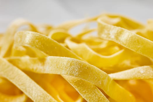 Yellow dried fettuccine , long flat pasta, healthy eating