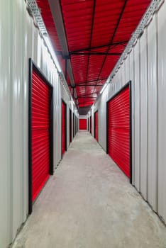 Corridor of self storage unit with red doors. Rental Storage Units