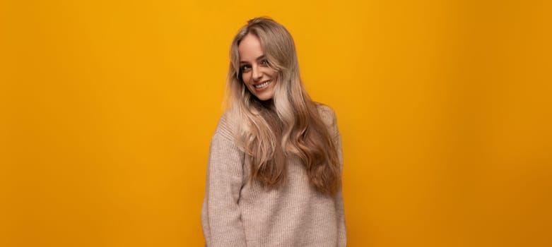 european girl smiling on yellow background.