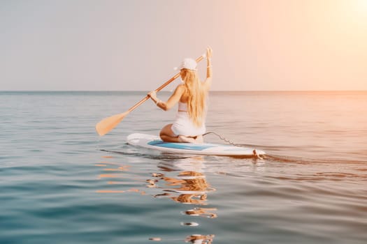 Close up shot of beautiful young caucasian woman with black hair and freckles looking at camera and smiling. Cute woman portrait in a pink bikini posing on a volcanic rock high above the sea