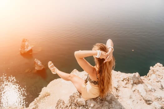 Woman travel sea. Happy tourist taking picture outdoors for memories. Woman traveler looks at the edge of the cliff on the sea bay of mountains, sharing travel adventure journey.