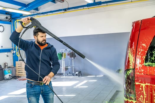 wash cars with water pressure from a sprayer on a hand washer. High quality photo