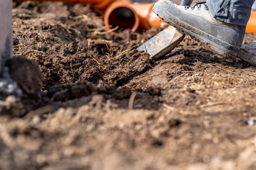 digging in the ground for plastic pipes for water and waste.