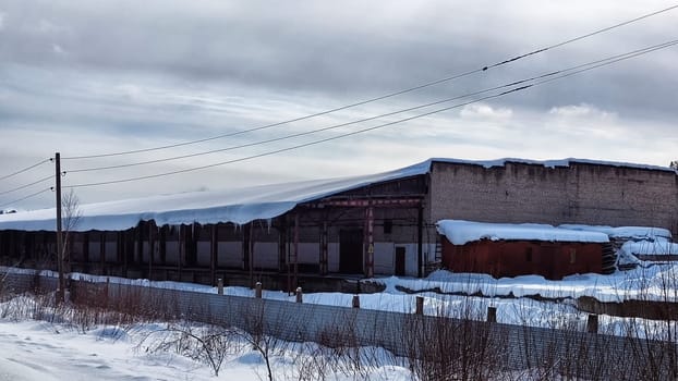 Abandoned Industrial Buildings in winter day and sky with white clouds on the Background