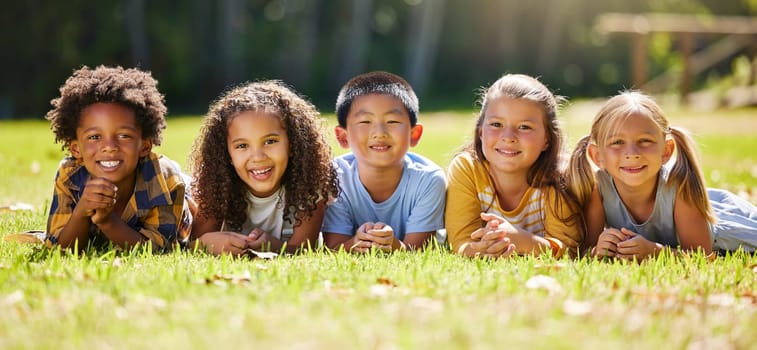 Portrait, diversity and children on grass, friends and summer break with smile, chilling and relax. Face, kids and young group in park, multiracial and fun on vacation, weekend and joyful together.