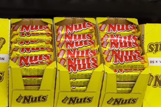 Tyumen, Russia-March 22, 2023: Nuts chocolate bars sweet food on the shelves of a grocery hypermarket.