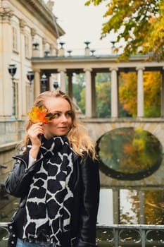 Tourist attraction woman travel enjoying nature sightseeing Baths classicist Palace on the Isle in Lazienki Park touristic place in Warsaw. Lazienki Royal Baths Park, Warsaw Poland. Colorful Autumn Foliage and Mirror Reflection on the Lake. Yellow leaves Nature in autumn Baroque columns