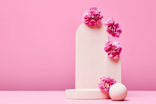 podium with flowers and elegant arch on pastel pink background. stage for presentation cosmetic or beauty product. minimal fashion design. copy space