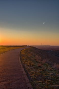 Vertical shot of an empty walkway on top of a hill at Halde Hoheward during sundown in Germany