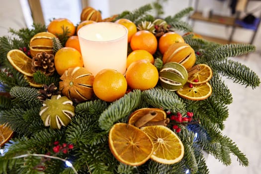 Christmas tree wreath with white candles, dry orange, cone. eco-friendly home decoration
