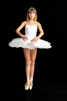 portrait of a teenage ballerina in a suit on a black background. High quality photo