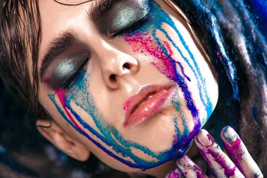 Bodyart model girl portrait with colorful paint make up. Sexy woman bright color makeup. Closeup of vogue style lady face, Art design. Black background
