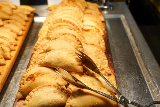 Curry puff or pastels on tray with tong for breakfast.