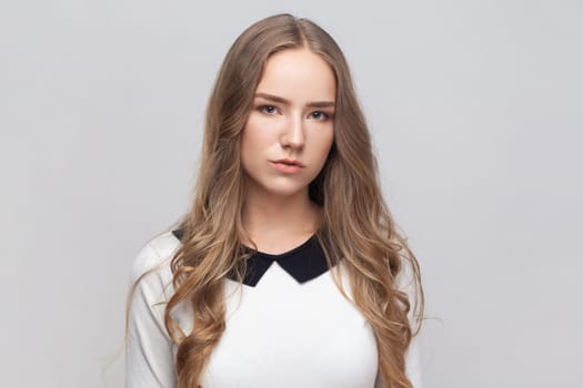 Portrait of upset sad attractive young adult woman with long blond hair looking at camera with unhappy sad expression, tired of being lonely. Indoor studio shot isolated on gray background.