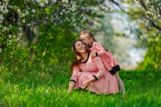 mother and daughter in nature in identical dresses