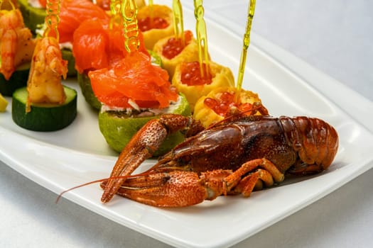 A closeup shot of cooked cancer with appetizers on skewers on the plate