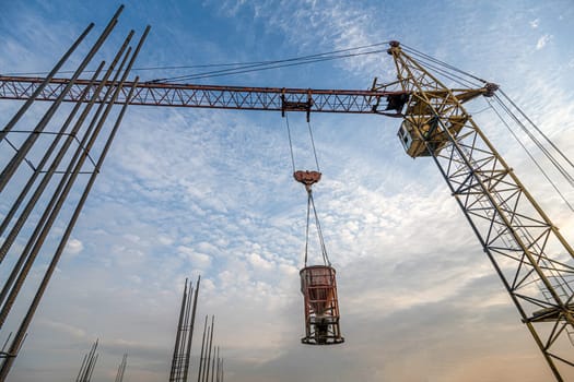 A low angle shot of a crane with equipment on a construction site near a new building infrastructure