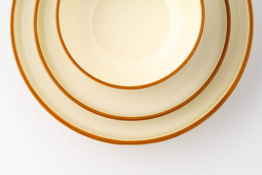 A set of white and brown ceramic plate and bowl on a white background. Close-up