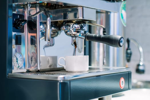 A closeup shot of a coffee being poured in a mug from a coffee machine