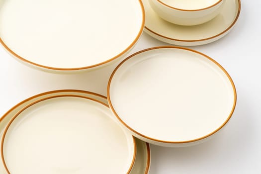 A set of white and brown ceramic plate and bowl on a white background