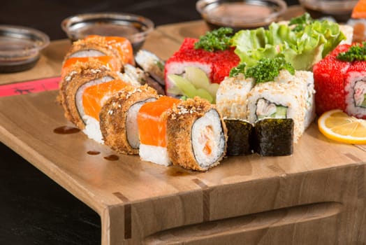 A closeup shot of a sushi set on a wooden plate