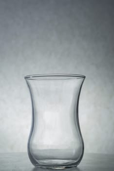 A vertical shot of an empty glass on a grey background