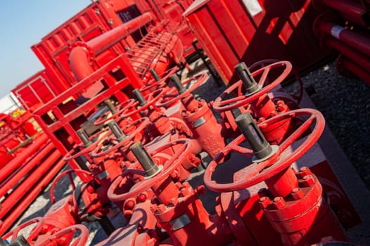 A closeup of a red industrial oil pipeline valves