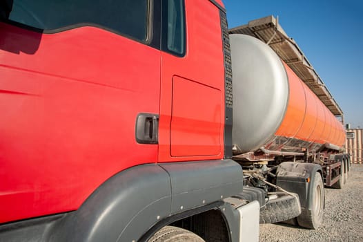 A closeup gas red tanker truck at an industrial construction site