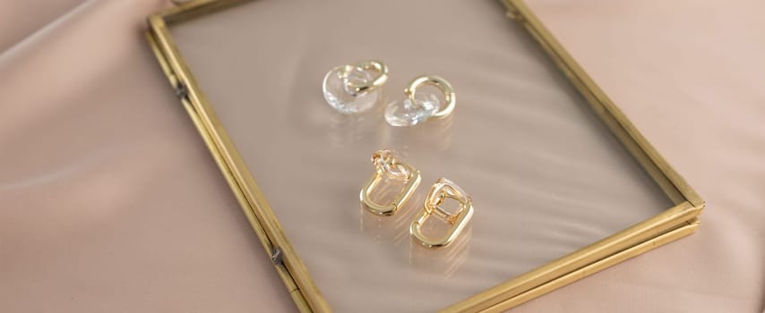 Elegant jewelry set of gold earrings with dried flower background. Jewelry set minimalist style. Handmade bijouterie