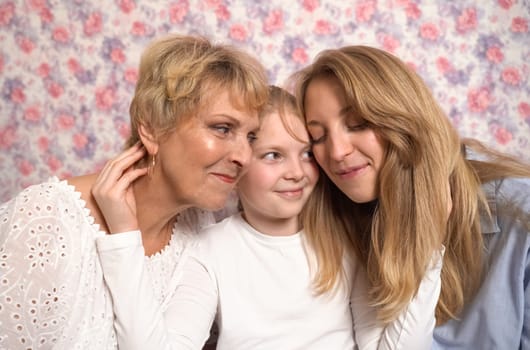 A teenage girl hugs her grandmother and mother, expresses her love to them.