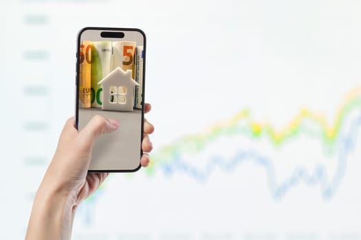 Phone in hand against the background of investment chart, investment concept, broker services, real estate value, economic growth, dividend payout, copy space.