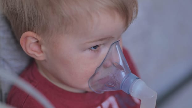 Funny boy breathing through an inhaler mask