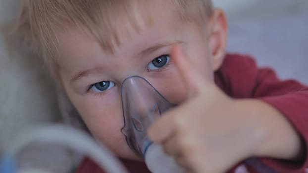 Funny boy breathing through an inhaler mask