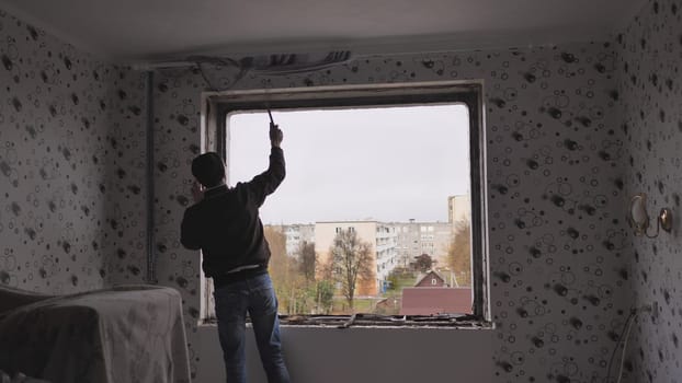An employee removes an old wooden window