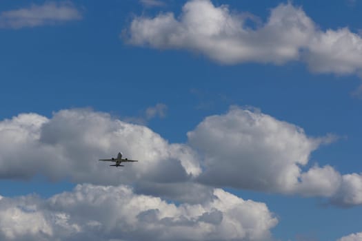 Airplane flies against a background of white clouds