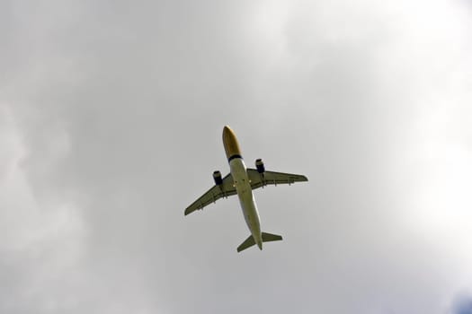 Airplane flies against a background of white clouds