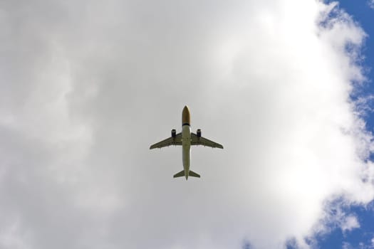 Airplane flies against a background of white clouds