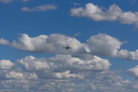 Airplane flies against a background of white clouds