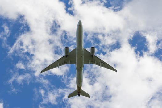 Airplane flies against a background of white clouds