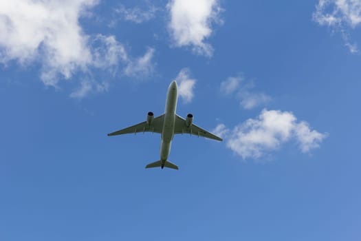 Airplane flies against a background of white clouds