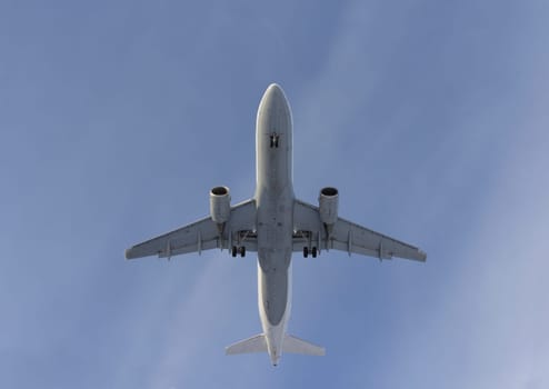 Airplane flies against a background of white clouds
