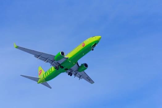 Airplane flies against a background of white clouds